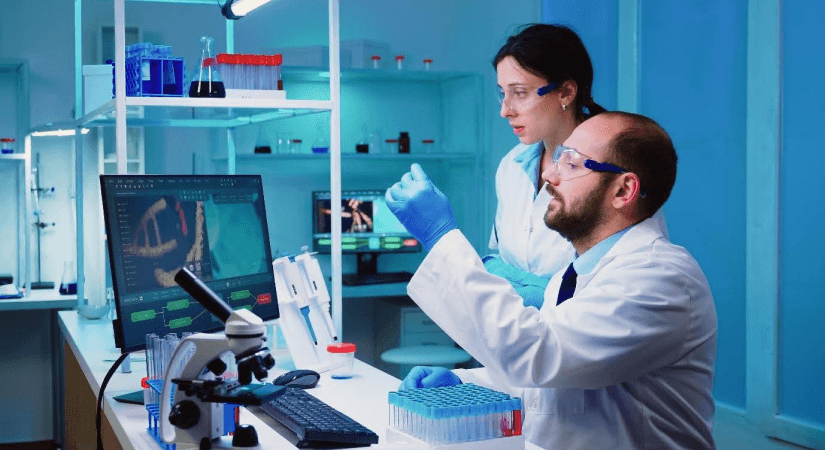 Physician Scientist Collaboration | Translational Research in Microbiology Two scientists collaborating in a microbiology lab analysing pathogen data